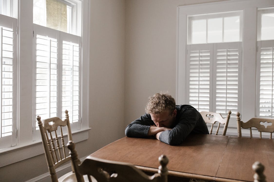 a man struggling to navigate his thoughts at a dining table