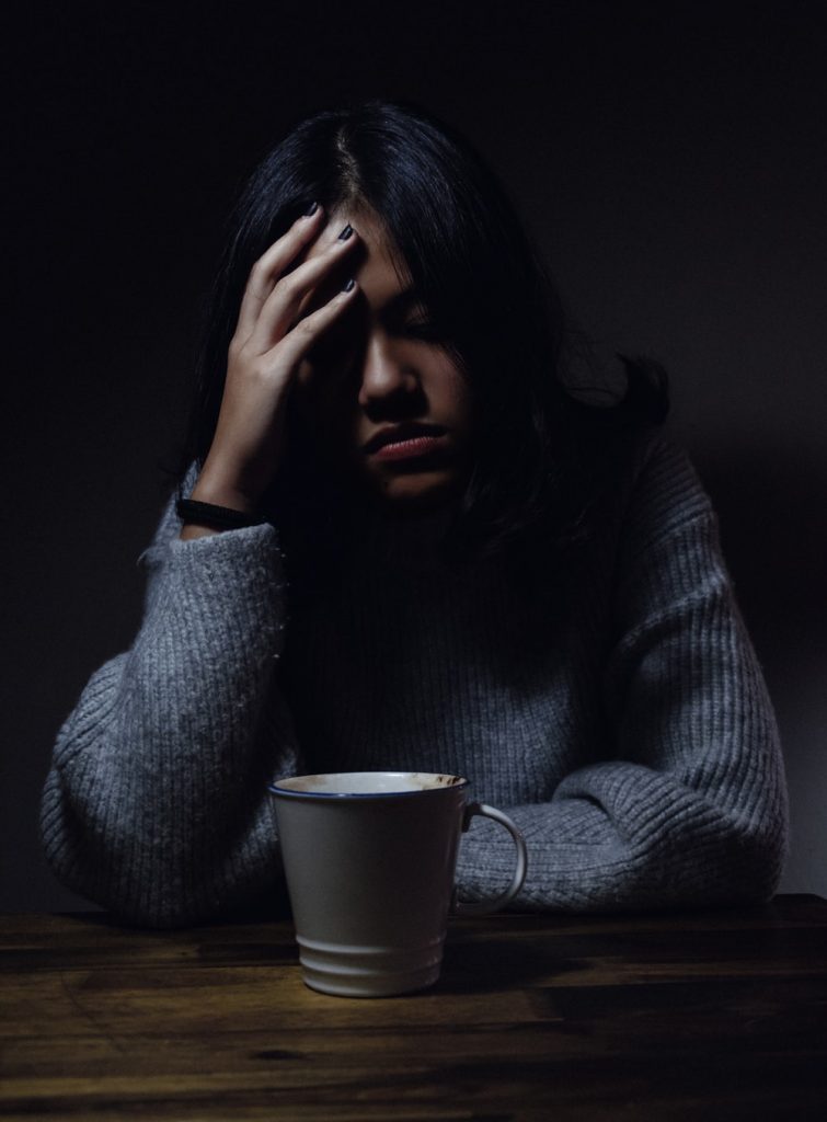 a woman distressfully holding her head