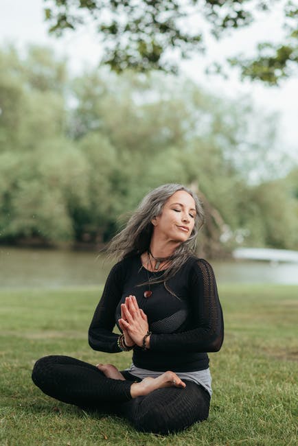 A woman meditates in an outdoor space, channeling the powers of her conscious and subconscious mind.